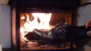 Burning wifes brown buckle shoe in the fireplace