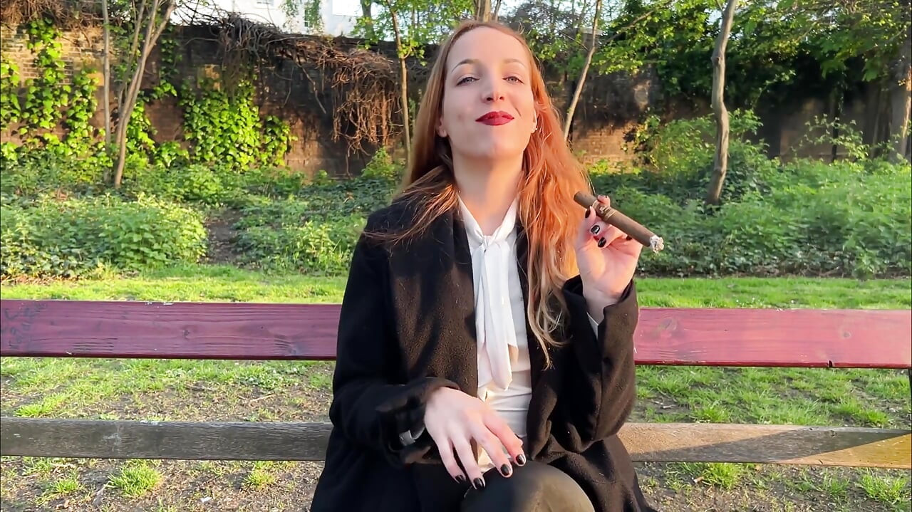 Liz Duga puši cigaru flor de Oliva na otvorenom