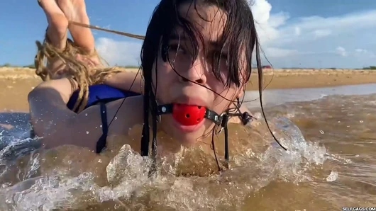 Ball Gagged Latina Hogtied In The Sea