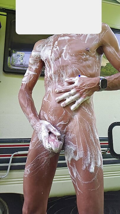 Skinny boy showers outside in front of the camper while the neighbor next door works. Big cock wash and piss risky outdoor