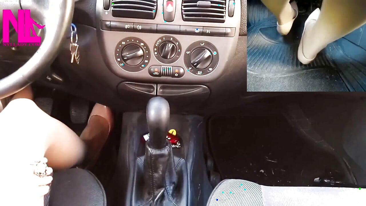 נהיגה חושנית בנעלי עקב עורומות של Gianvito Rossi ועבודה ביד על ידית ההילוכים של המכונית