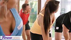 Salas de fitness escote sudoroso en una habitación llena de chicas de yoga