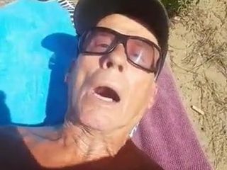 Neuk een oude man op het strand