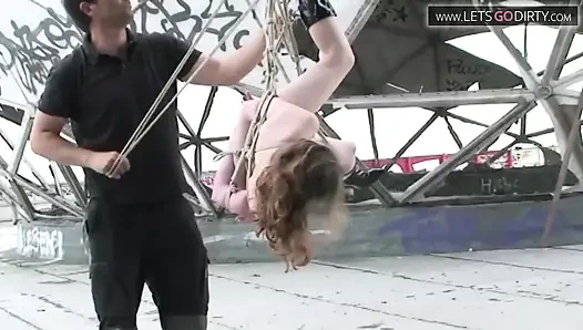 Blondes schätzchen wird gefesselt und mit seilen aufgehängt