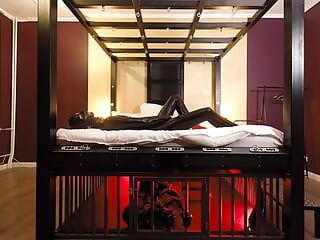 Noites de borracha: a escrava de borracha descansa apertada em uma gaiola debaixo da cama