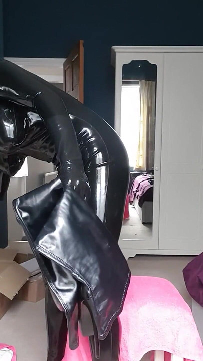 乳胶服娘娘腔娃娃拉起她的大腿高靴子并展示它们