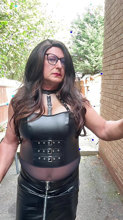 Seksi transvestit kellycd2022 u crnom PVC bodiju i mrežastim čarapama i štiklama