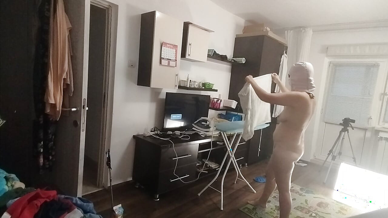 Sexy brunette doing naked chores around the house.