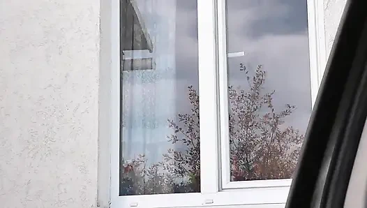 Naked in public. Taxi driver watches from car as woman in robe without panties and bra in stockings washes an apartment window