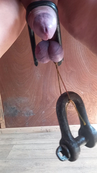 Cbt,Testicles tied off with weights attached.