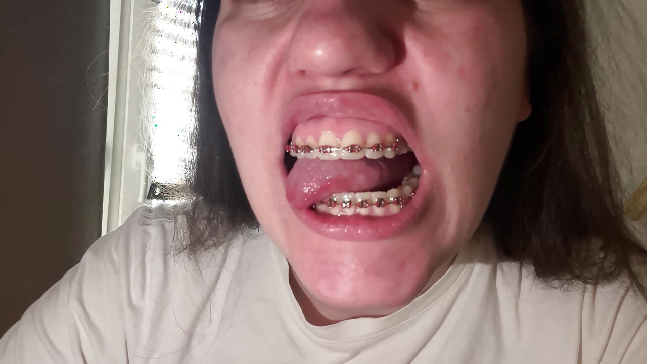 Lambendo seu aparelho com sua língua