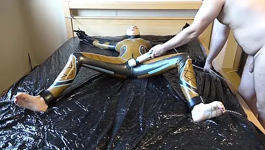 Latex Danielle wird am Bett befestigt und mit der massage mit dem vibrator masturbiert