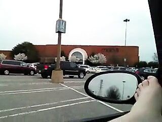 Gatinho peludo brincando e esguichando no carro no estacionamento do shopping