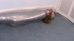Fată înfășurată în bandă adezivă ca o mumie