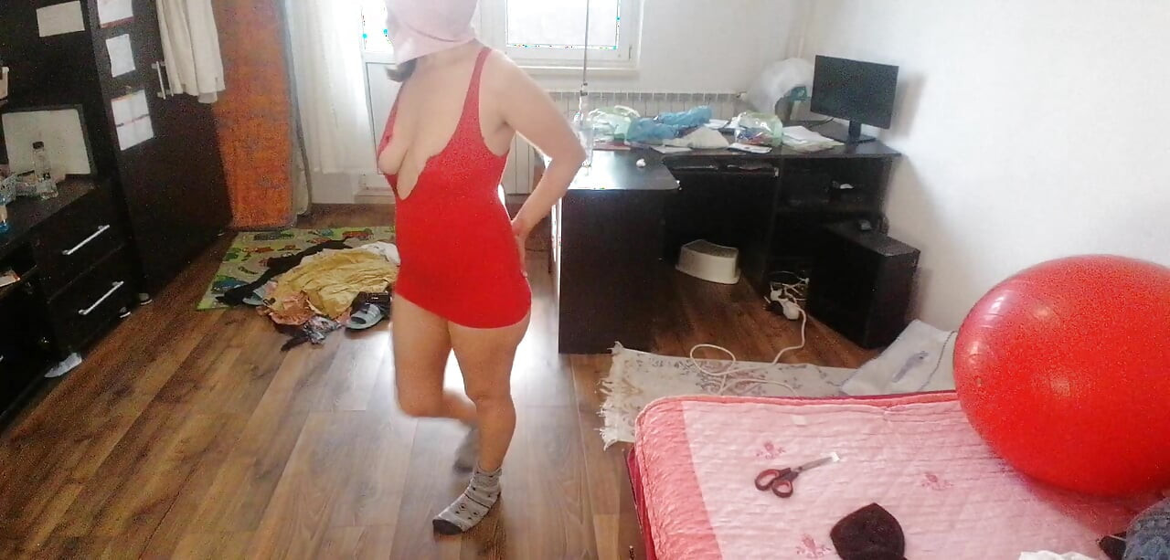 Amateur woman has fun trying on clothes and cutting them.