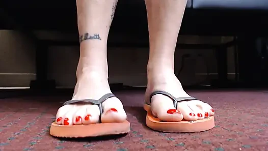 Игра с шлепантом обуви с красными ногтями крупным планом