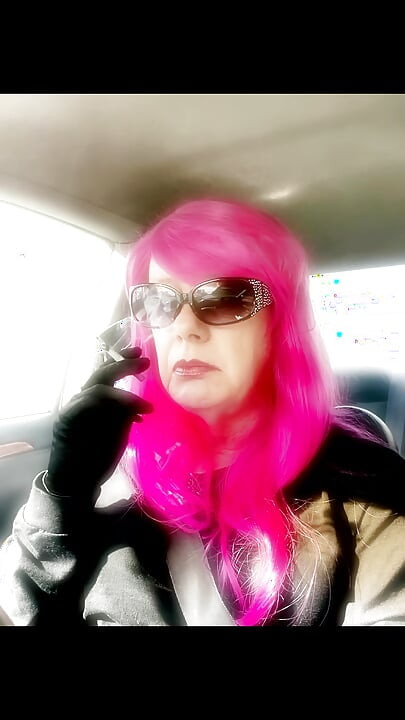 Mrs. Roman TG dengan rambut merah jambu dan sarung tangan kulit merokok vs120s menthol memandu CD ladyboy matang merokok fetush