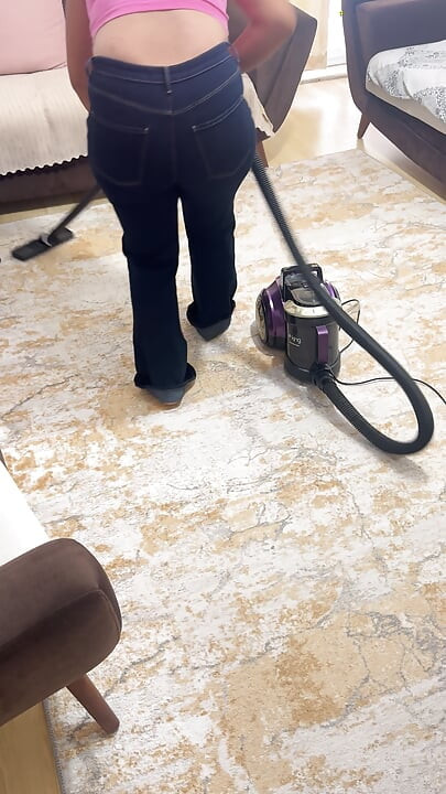 Vrouw met ronde vormen die het huis schoonmaakt in een broek