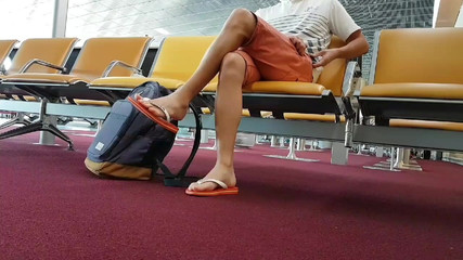 Jongen trok teenslippers en enkelband aan op de luchthaven