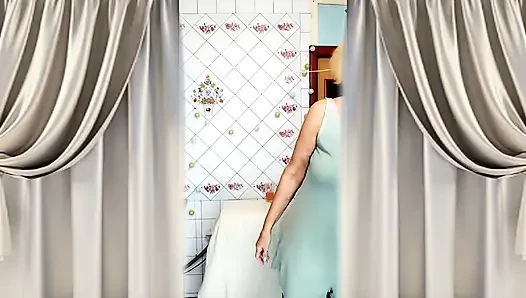 Heiße hausfrau Lukerya mit zerrissenen haaren trinkt tee und twerks in der küche.