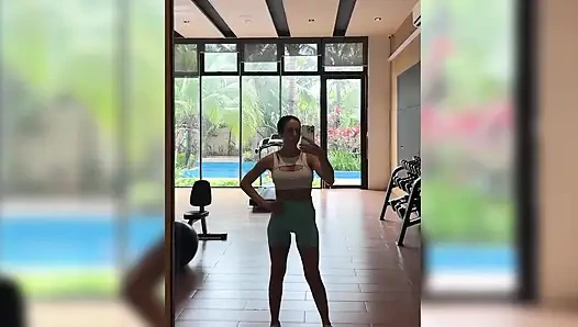 Seksi egzersiz, topun üstüne atlama, halka açık bir spor salonunda göğüslerini teşhir ediyor