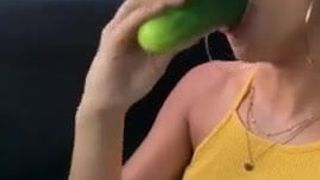 Una donna che mangia un cetriolo