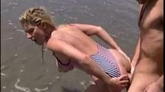 サリーはレトロ映画でビーチに横たえた