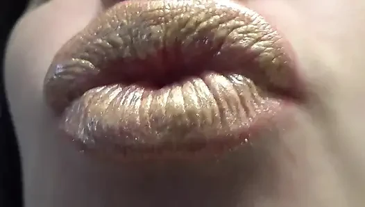 Bibir emas menggoda dan mengisap lolipop dan menjilati