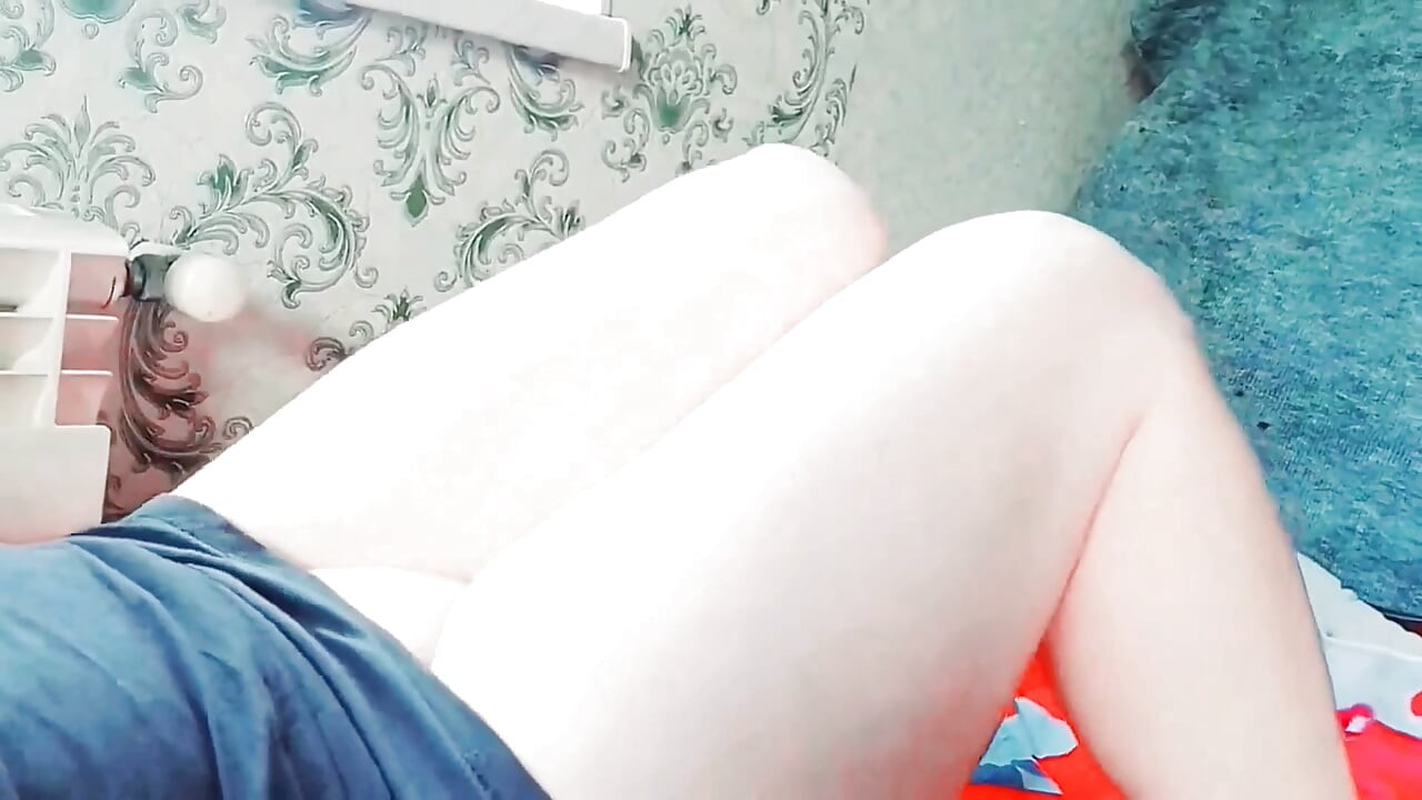 Cute femboy lifting skirt slightly under soft lights