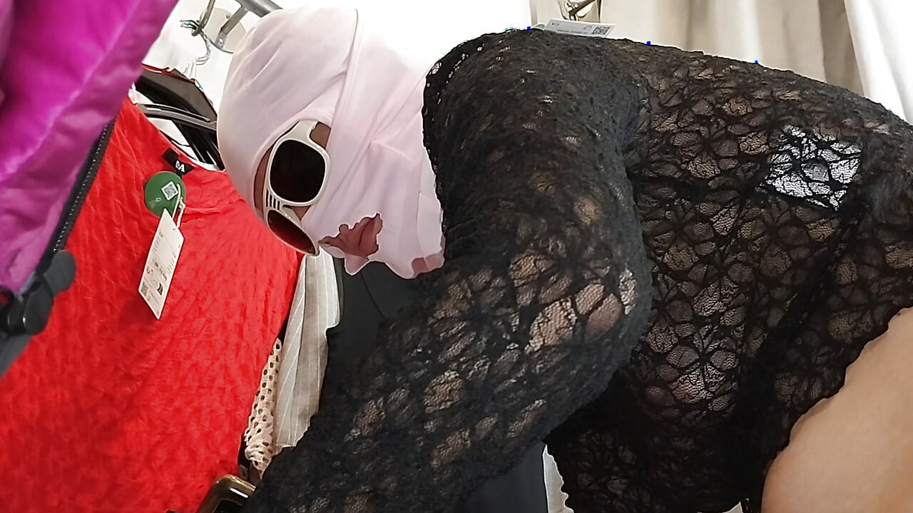 Sexy žena si zkouší oblečení nahá ve zkušební kabince.