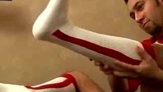 Chico lindo muestra calcetines de béisbol rojos con estribo