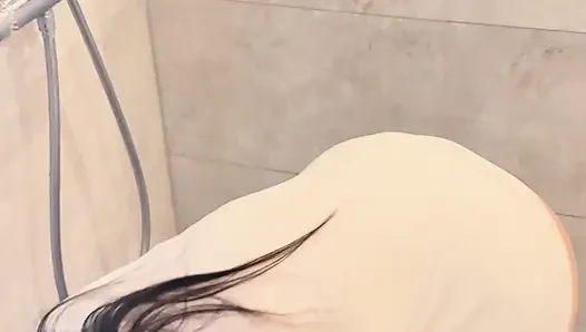 Sırılsıklam kapşonlu kızla banyo zeminini temizliyor, dizlerinin üzerinde