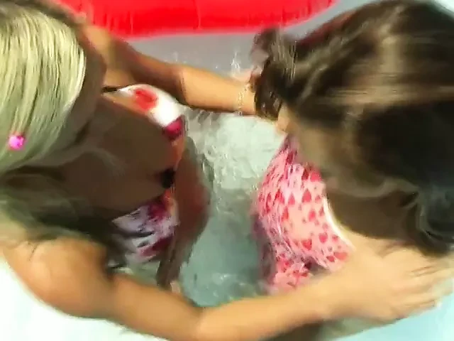 Lesbians have fun with a dildo at pool party
