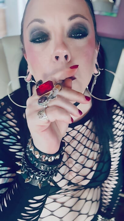 Chica gótica Tina Snua en coletas fuma un cigarrillo en un soporte y se enciende con cerillas