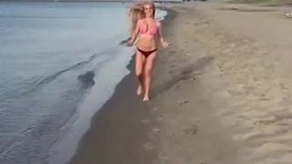 Stuiterende tieten die op het strand lopen