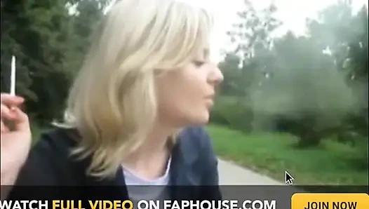 Блондинка-красотка курит сигарету на улице