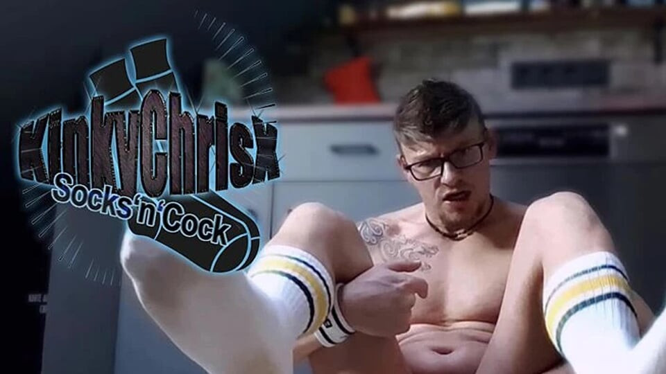 KinkyChrisX se igra sa svojom dečačkom pičkom u kuhinji noseći bele čarape