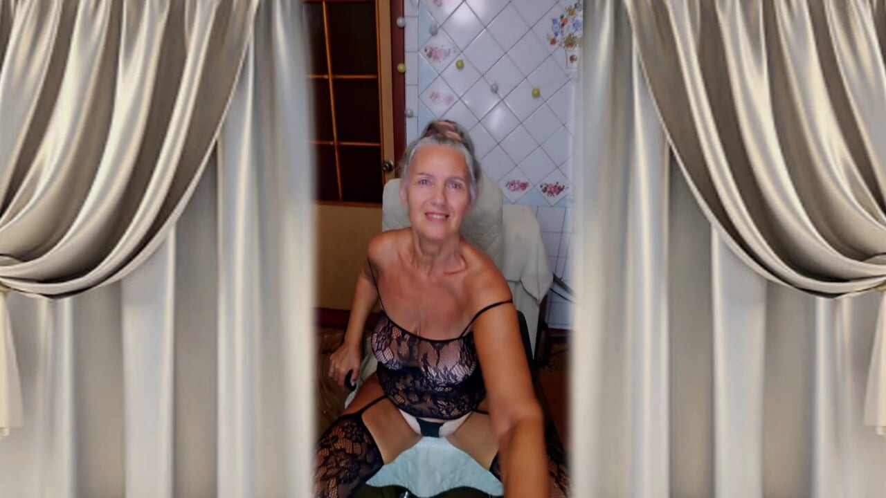 Hot housewife Lukerya flirts in a black fishnet dress at home in the kitchen.