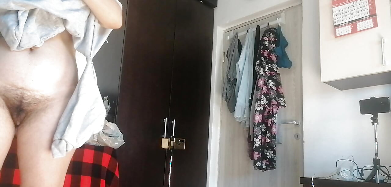 Amateur woman has fun trying on clothes and cutting them.