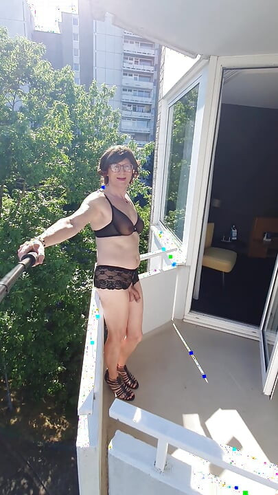 Pointing on the balcony in lingerie