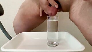 小さなペニスがコップ1杯の水に射精して放尿