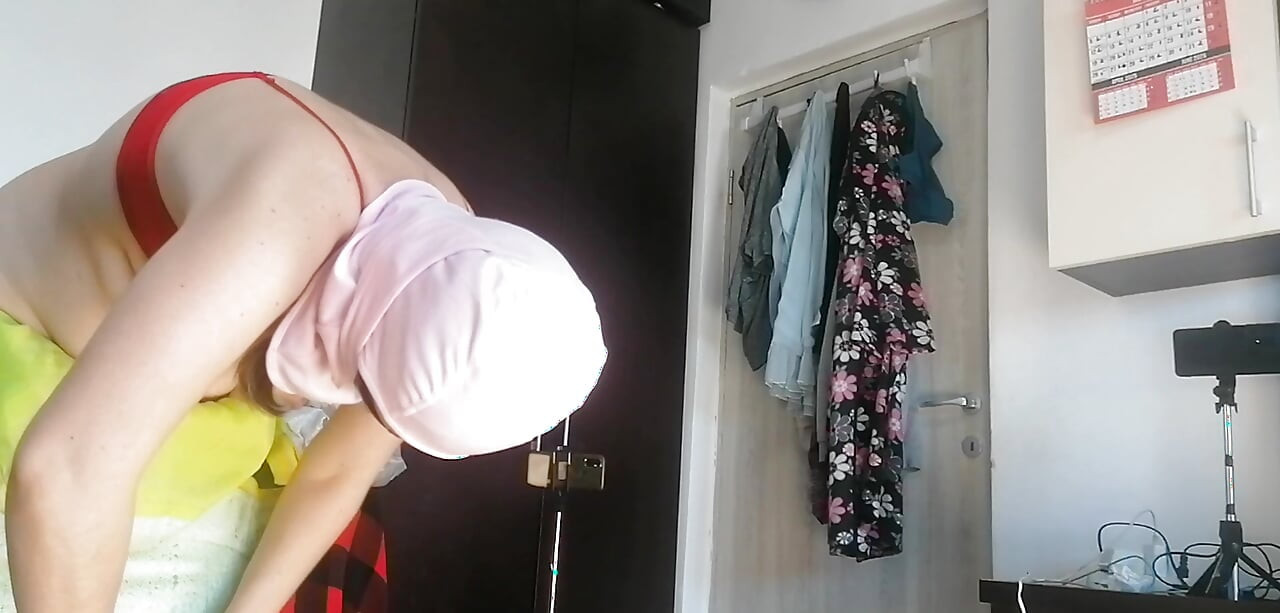 Amateur woman has fun trying on clothes and cutting them.