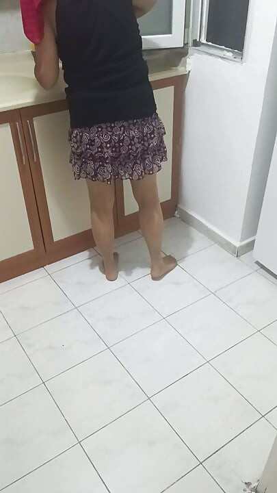 Mature woman in sheer stockings doing housework in the kitchen.
