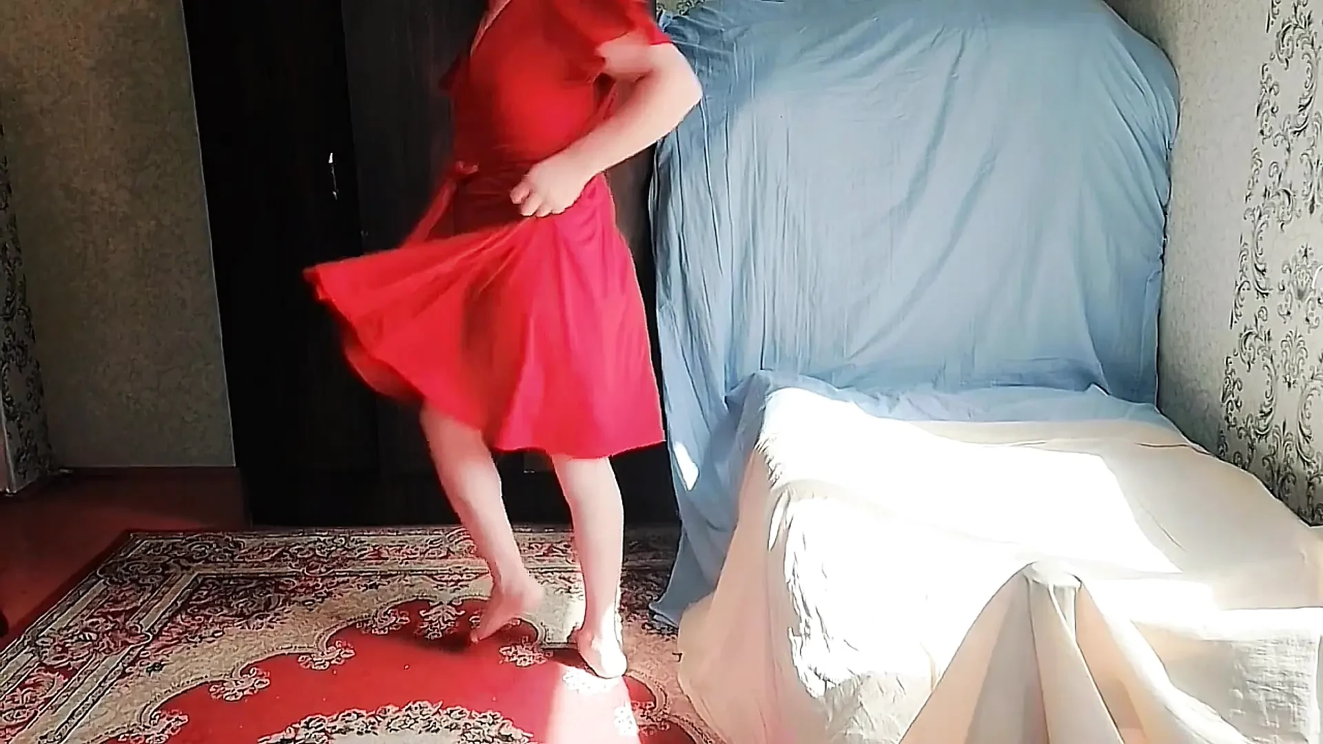 Játékos sissy ül keresztbe tett lábakkal bolyhos rózsaszín szőnyegen