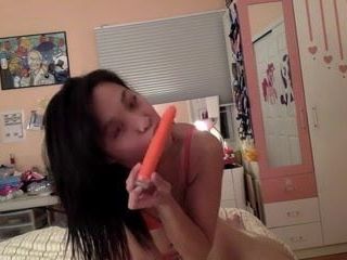 Sexy asiática brinca com seu vibrador laranja (sem nudez)