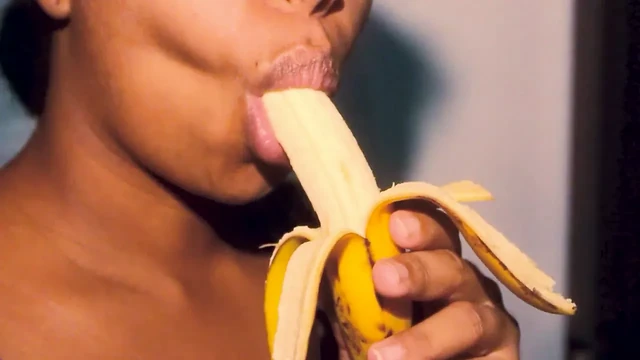 Naughty ebony with sexy lips playing with a banana