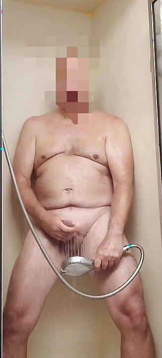 Exhibitionist masturbating with showerhead, stroking, cumming, and eating