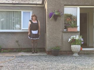 Sissy maid neil i sin pigor uniform utanför sitt hus