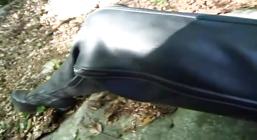 Lonely slave in fetish clothes walking in the woods