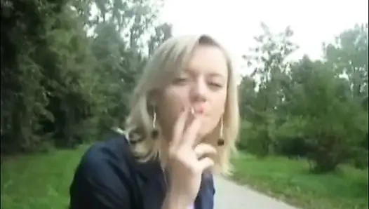 Blonde beauty smoking a cigarette outdoors